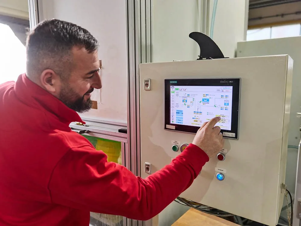 Mitarbeiter bedient das Steuerpanel einer Polyurethan-Anlage